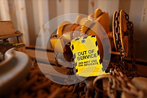 Yellow out of service tag attached on faulty damage defect of heavy duty lifting beam trolley at construction site Perth