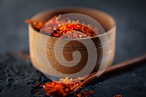 Saffron. Indian spices in wooden bowl on black stone table. Spice and herbs on slate background. Cooking