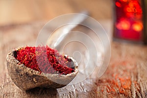 Saffron spice in antique wooden spoon on old wood background