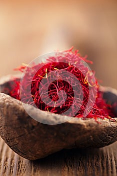 Saffron spice in antique wooden spoon on old wood background