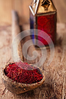 Saffron spice in antique wooden spoon on old wood background, cl