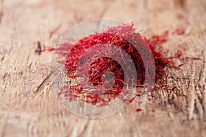 Saffron spice in pile on old wooden background