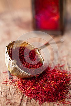 Saffron spice in rustic sieve on old wooden background