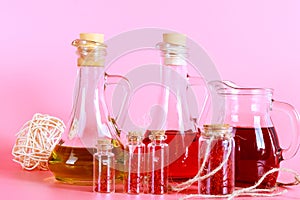 Saffron stamens in small jars and saffron stamen drinks on a pink background.