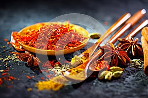 Saffron. Various Indian Spices on black stone table. Spice and herbs on slate background photo