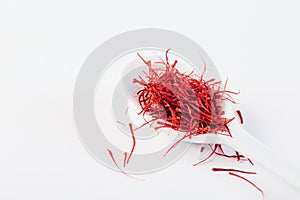Saffron in white spoon on white background