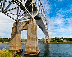Sagamore bridge spans Cape Cod Canal under a sky dominated by Cirrus clouds