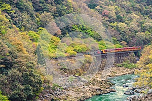 Sagano Romantic train running above river Kyoto Japan photo