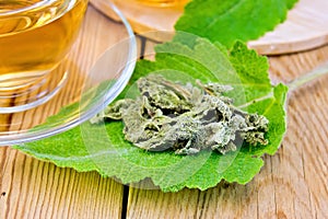 Sage dried on fresh leaf with cup on board
