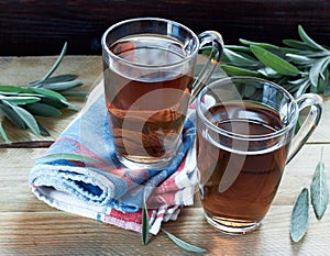 Sage herbal tea or decoction in a glass cups with herb leaves