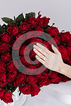 she said yes. close-up of woman hand with engagement rings. Hand of the on the background of the big bouquet of red