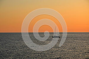 Sail boat cruises on Black Sea as sun sets on horizon Batumi Georgia