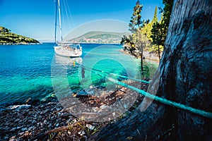 Sail boat docked alone in emerald hidden lagoon among picturesque mediterranean nature Ionian Islands, Greece