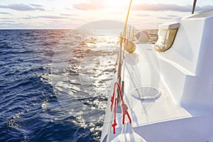 Sail boat gliding in open sea at sunset. Yachting as a luxury sport and great vacation