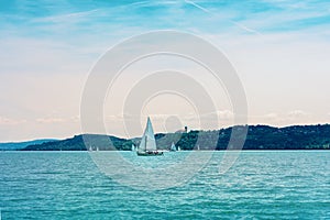 Sail boat on the lake Balaton view of Tihany abbey from Balatonfured before sunset