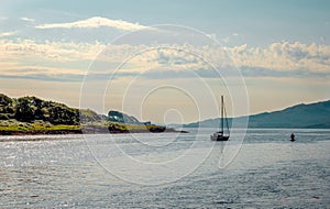 A sail boat leaves Loch Aline behind photo