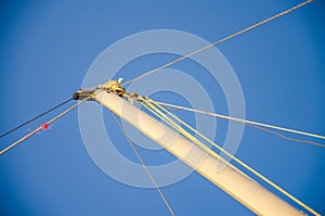 Sail boat mast, bracing, hemp ropes, blue sky. Minimalist maritime theme. History of water transport