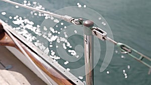 Sail boat navigating in the ocean sunny day showing the wooden parts and closeup of the deck of a wooden antique