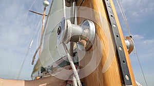 Sail boat navigating in the ocean sunny day showing the wooden parts and closeup of the sail of a wooden antique