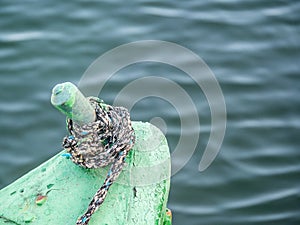 Sail boat rope tied to a bitt mooring bollard