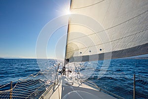 Sail boat with set up sails gliding in open sea