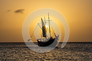 A sail boat silhouette against the sunset