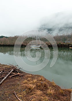 A sail boat sits in harbor near Howe Sound