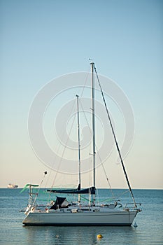 Sail boats anchored on a calm sea in late afternoon