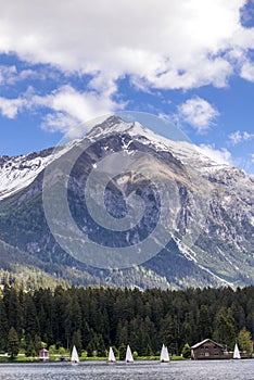 A sail boats regatta on the lake of Lenzerheide in Switzerland with the Siwss Alps in the background photo