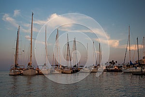 Sail boats and yachts anchored in marina.