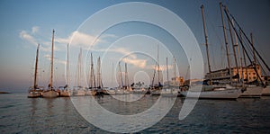 Sail boats and yachts anchored in marina.