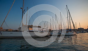 Sail boats and yachts anchored in marina.