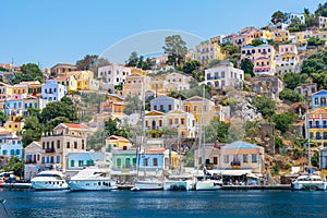 Sail boats, yachts and colorful houses in harbor town of Symi Symi Island, Greece