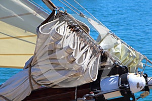 Sail folded back on the boom of a sailboat