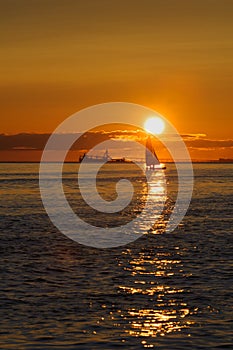 Sail and ship at sunset on Pacific ocean