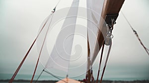 Sail on wooden sailboat with ropes and wooden blocks.