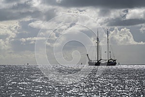 Sailboat against the glare of the sun in the sea