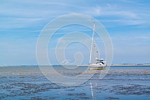 Sailboat aground on sandflat at low tide near Rotterdam, Netherl