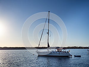 Sailboat anchored on a beach in the Formentera island during sunset.