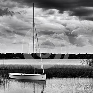 Sailboat anchored on lake during stormy day