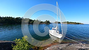 Sailboat anchored near remote rocky island in Stockholm archipelago. Adventure and travel concept