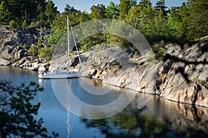 Sailboat anchored near remote rocky island in Stockholm archipelago. Adventure and travel concept