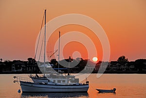 Sailboat anchored on river at sunrise