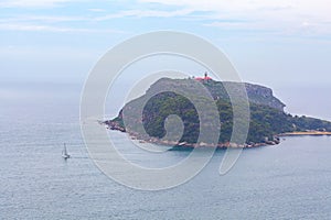 Sailboat and Barrenjoey lighthouse in misty weather.