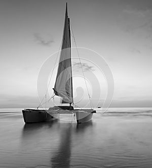 Sailboat on the beach with a beautiful sunset in black and white