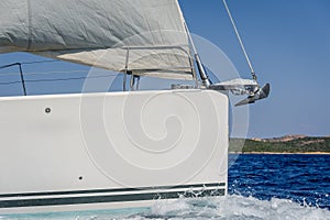 Sailboat bow with hoisted headsail and copy space on the boat hull. photo