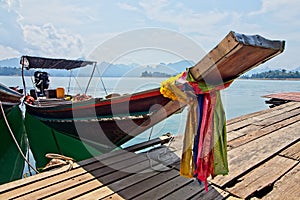 Sailboat with colorful ribbons at the port under the cloudy sky