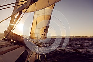 Sailboat crop during the regatta at sunset ocean