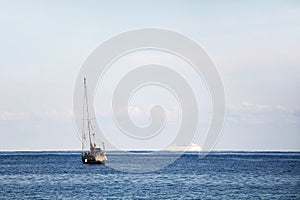 A sailboat and a cruise ship in the ocean