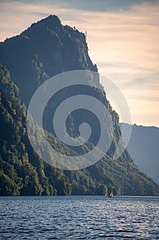 A sailboat in the distance in front of a big mountain